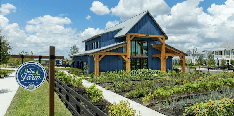 The Farm entrance sign with crop rows and garden beds, the Barn behind
