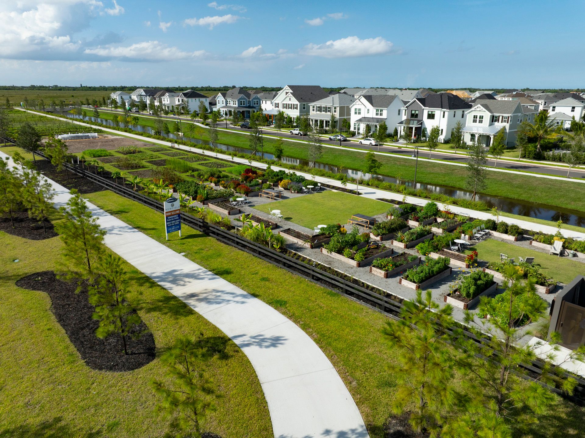 Aerial view of Newfield Farm's raised garden beds and resident plots, Rosette Park homes across the canal