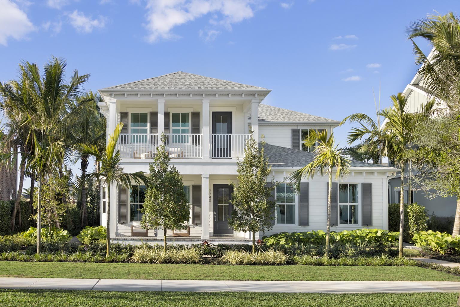 A two-story coastal-style Rosette Park home with double porches and palms